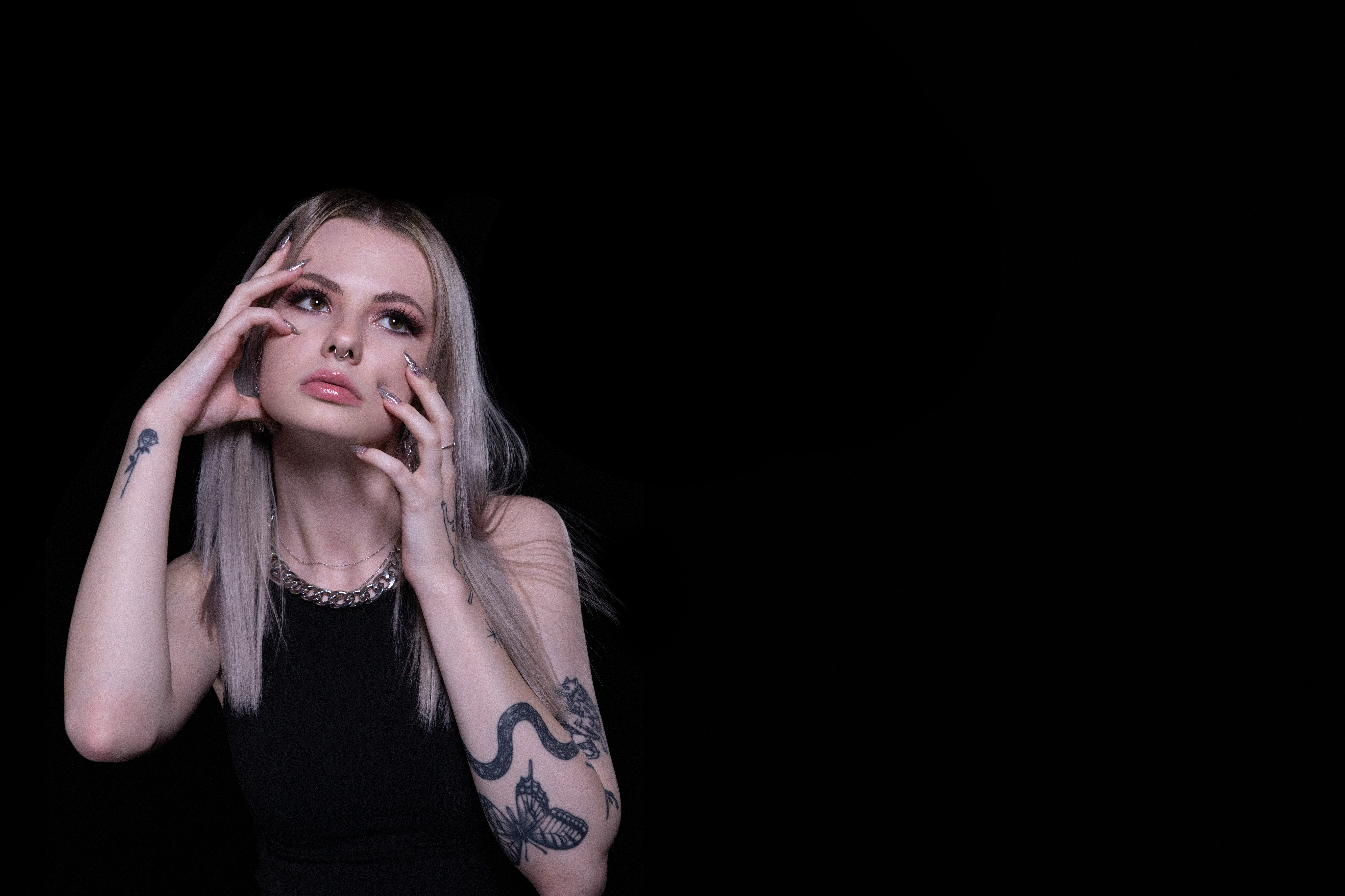 Portrait photography of me holding my head aggressively in my hands on black background. 