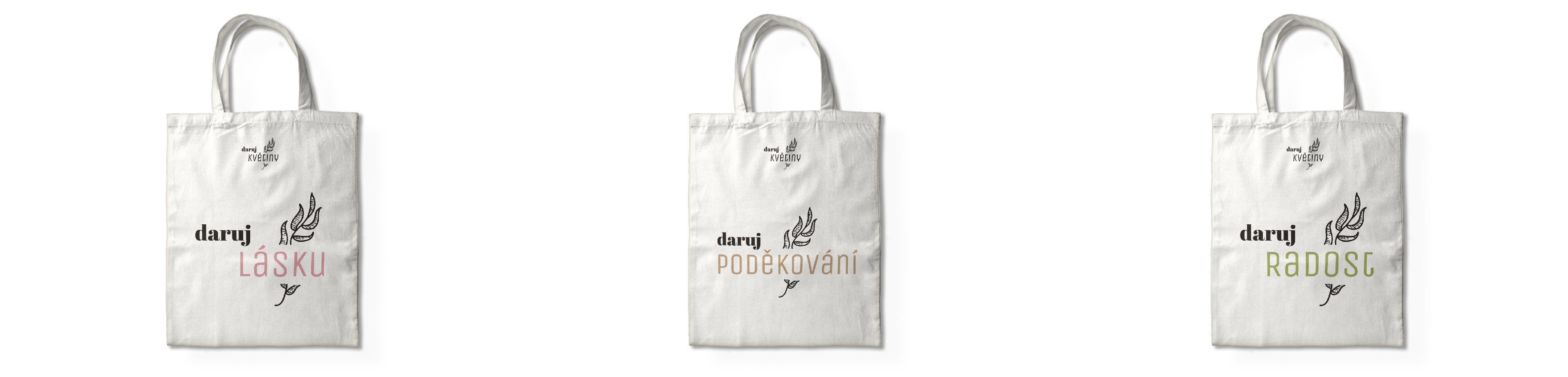Tote bags with different colored logos saying give love, give thanks, give joy. 